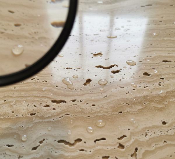 Porous travertine countertop with water droplets