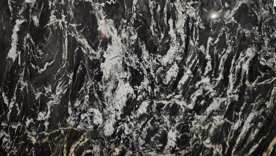 Black natural stone slab with bold white and gold veining