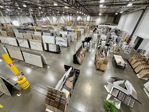 Extensive Nova Tile and Stone slab selection displayed in modern warehouse facility.