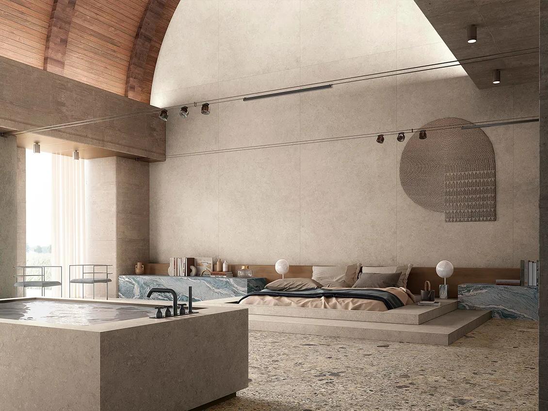 Spa bedroom with Palladium Ivory porcelain slabs on walls and soaking tub under arched ceiling