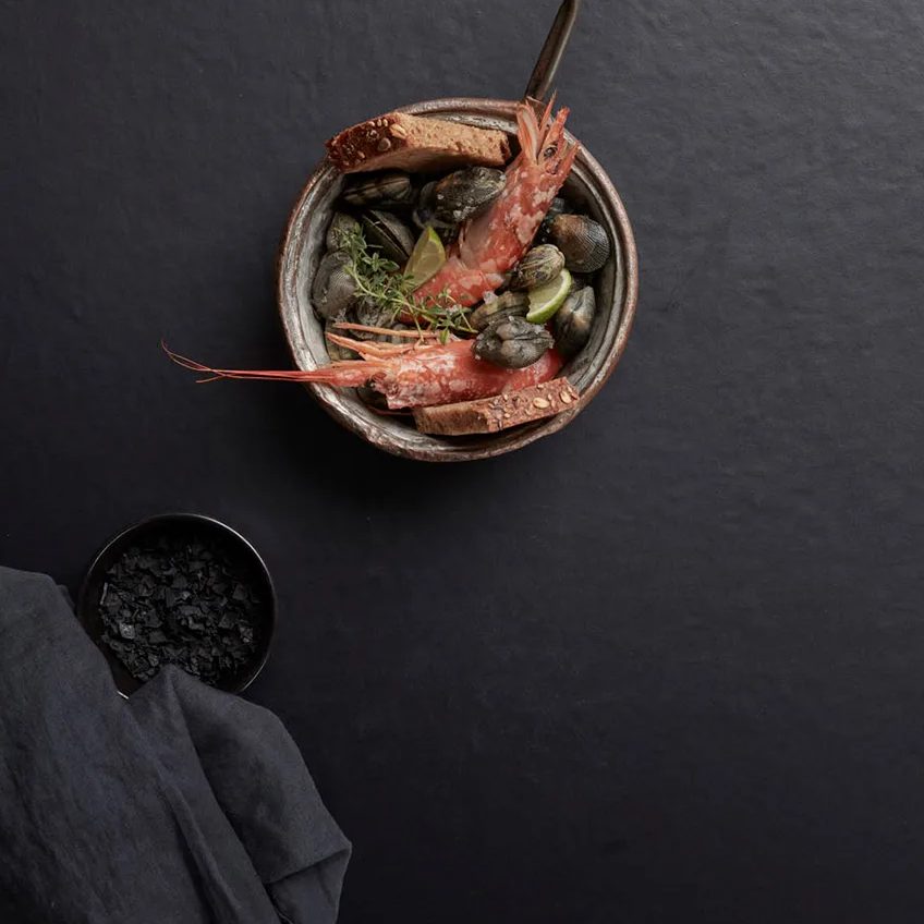 Prawns in a round bowl styled on the black Pigalle porcelain slabs surface.