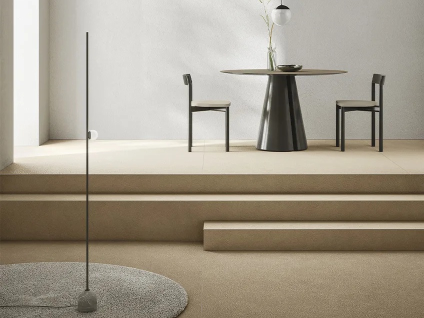 Modern dining space featuring Plaster Sand porcelain slabs as elegant neutral floor installation.