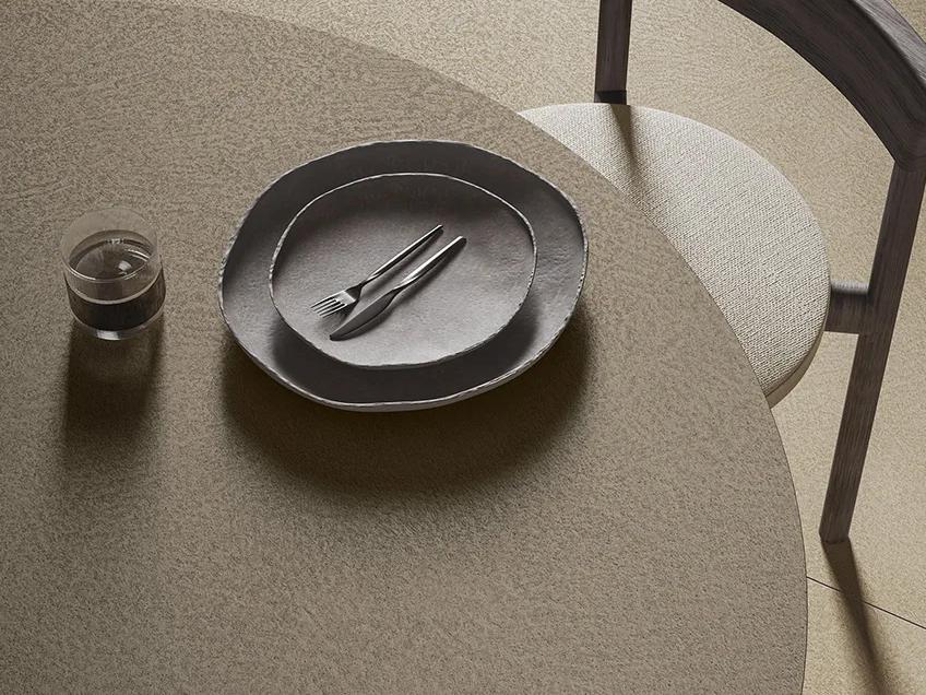 Plaster Sand porcelain slabs table surface with dining plate and chair overhead view.