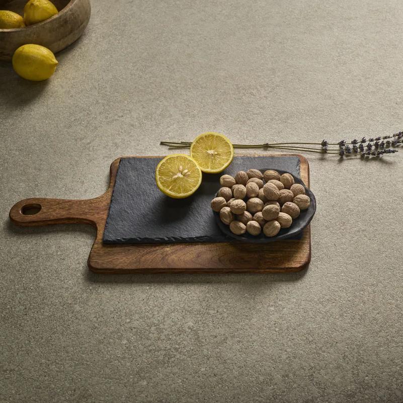 Styled cutting board with citrus and nuts showcased on Provençale porcelain slabs