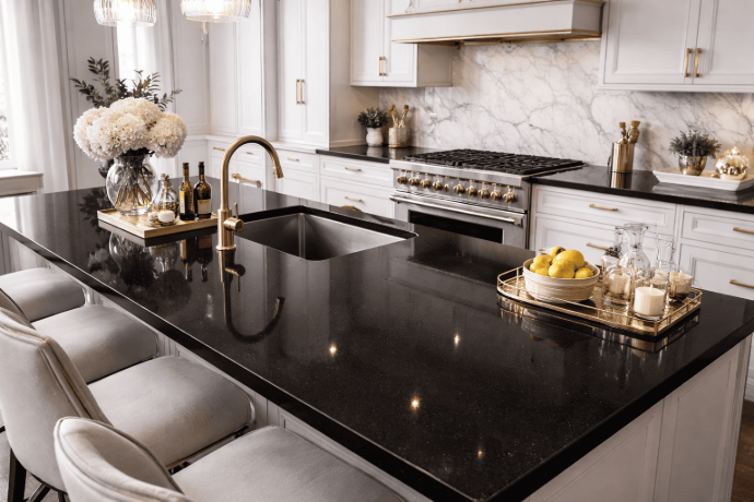 Absolute Black granite kitchen island worktop with white cabinetry and gold fixtures