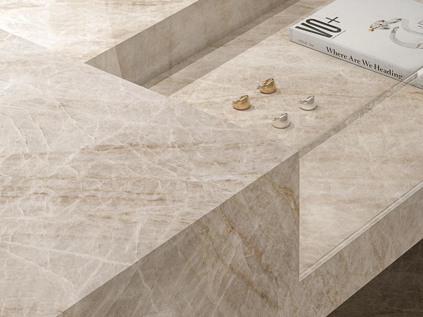 Top view of Taj Mahal porcelain slabs table with small gold accessories and a magazine