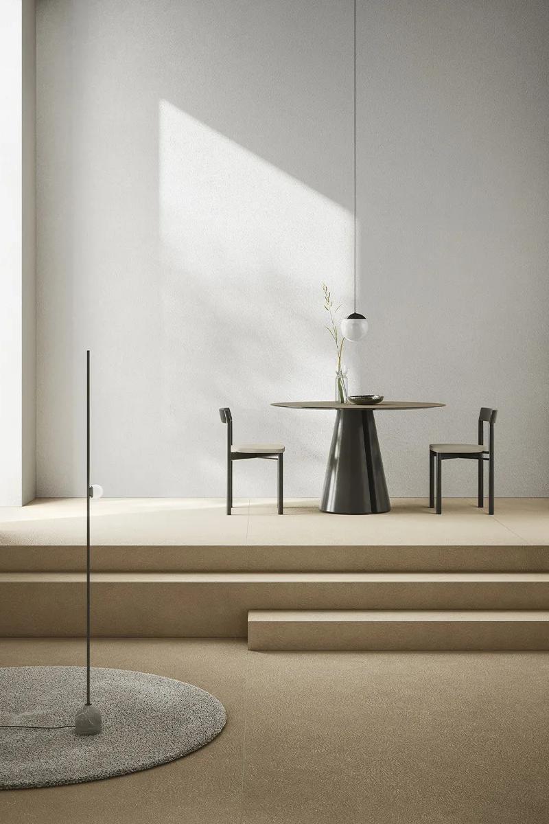 Modern dining space featuring Plaster Sand porcelain slabs as elegant neutral floor installation