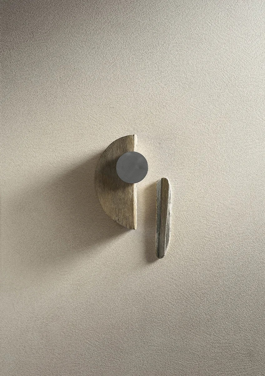 Close-up of Plaster Snow porcelain slabs texture with a small stone decor piece