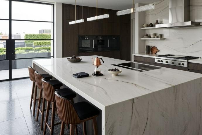 Mont Blanc quartzite waterfall island countertop with flowing gray veining paired with dark wood cabinetry