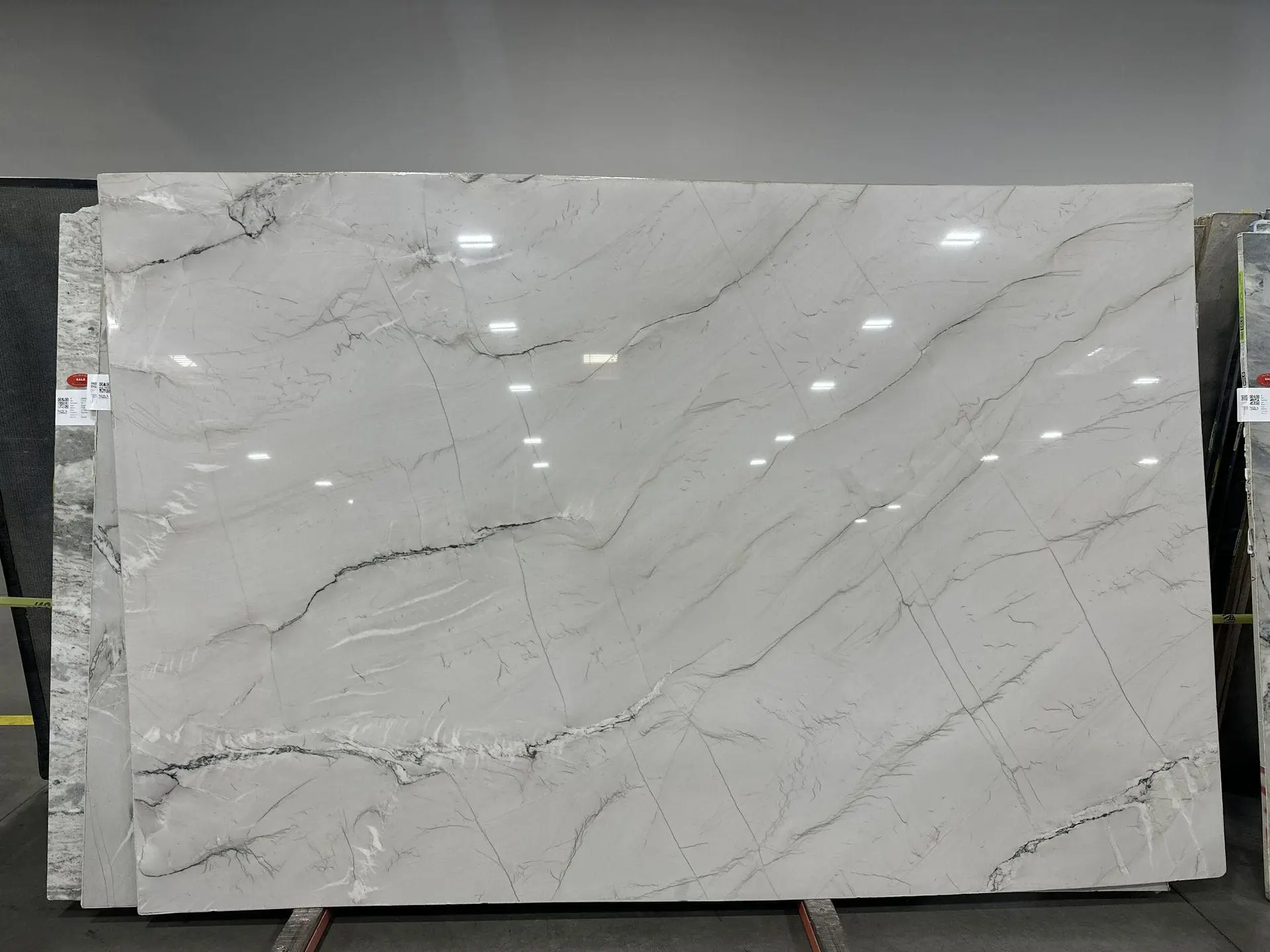 Zermatt quartzite slab with polished finish showing white base and soft gray veining in a showroom setting.