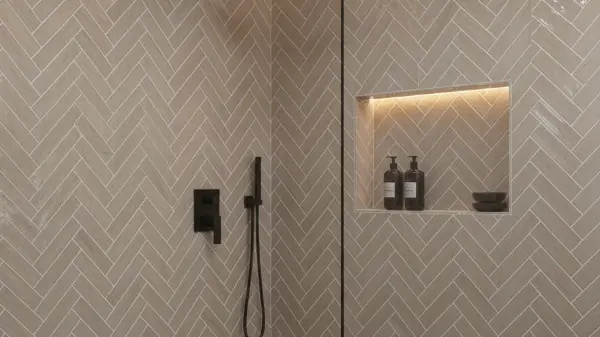 Close-up of a shower wall with beige herringbone subway tile