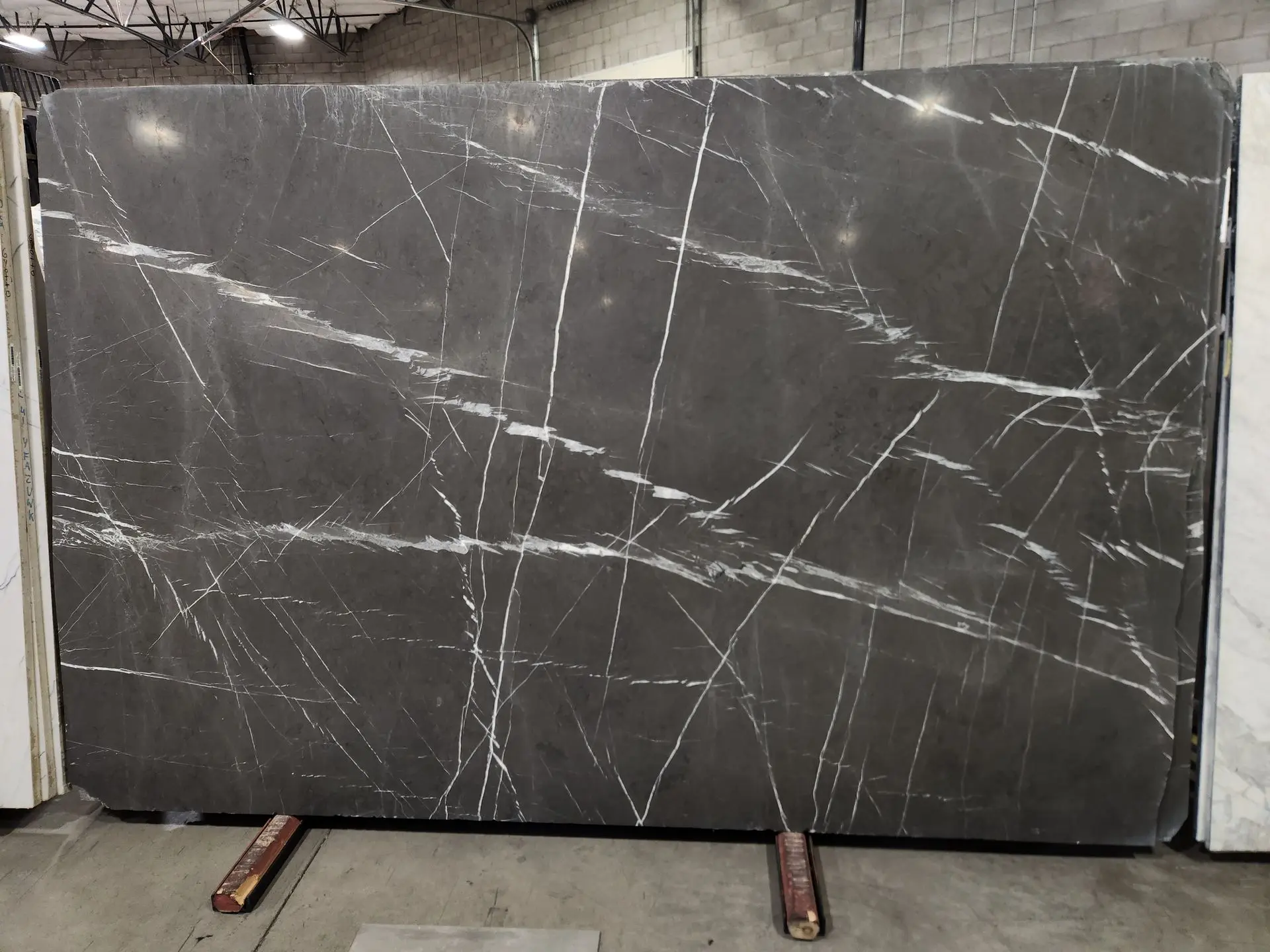 Graphite marble slab on display in Nova Tile and Stone showroom, honed finish with white veining