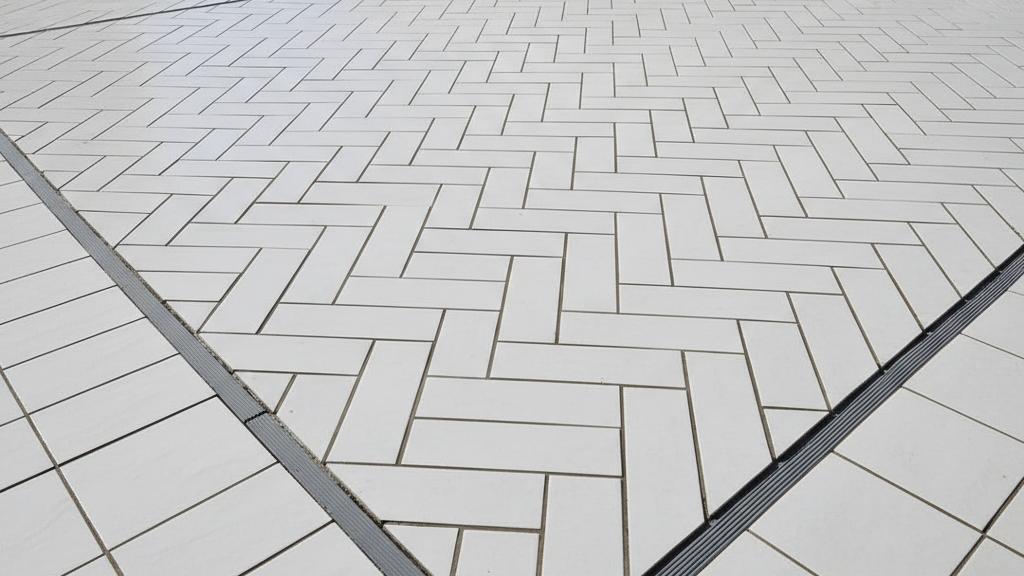 Modern herringbone subway tile pattern installation with proper expansion joints preventing future cracks