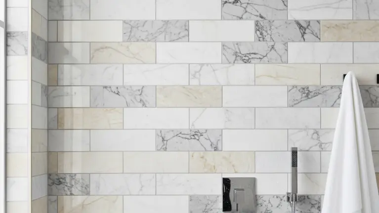 Shower wall with marble subway tile and white towel