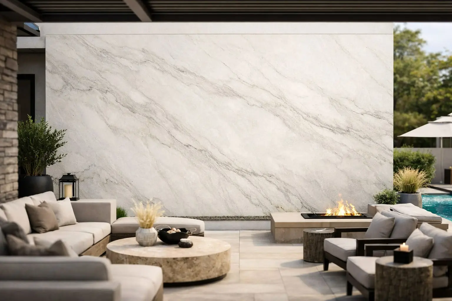 Off-white quartzite outdoor wall cladding with grey veining behind a covered patio with linear fireplace and neutral lounge seating