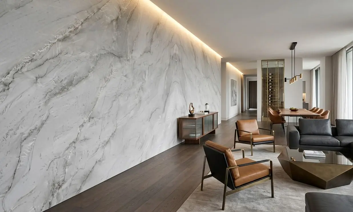 Conceptual rendering of a living room accent wall in leathered finish quartzite with dramatic grey veining, alongside leather chairs and a dark sofa