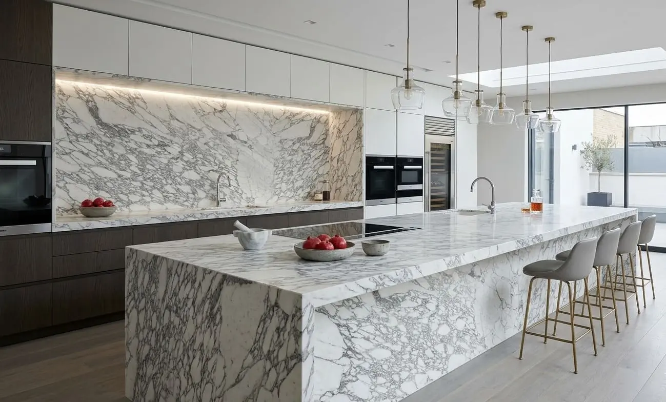 Luxurious white Calacatta marble kitchen with an expansive island and backsplash