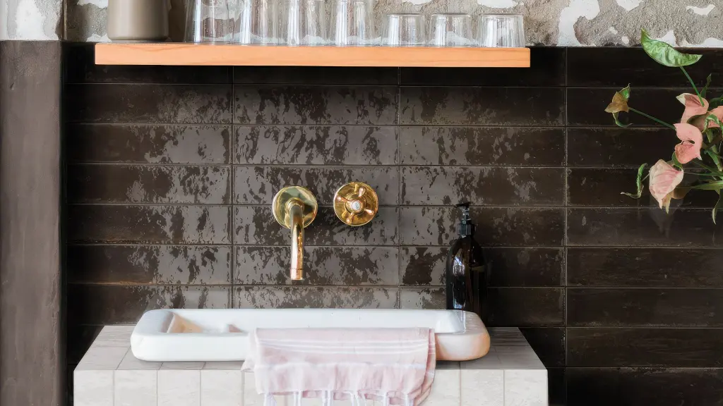 Dark subway tile bathroom wall showing a completed subway tile installation