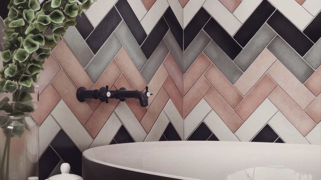 Artistic bathroom backsplash showcasing a mix of matte tiles, including the soft pink Perfection Blush, arranged in a decorative herringbone layout.